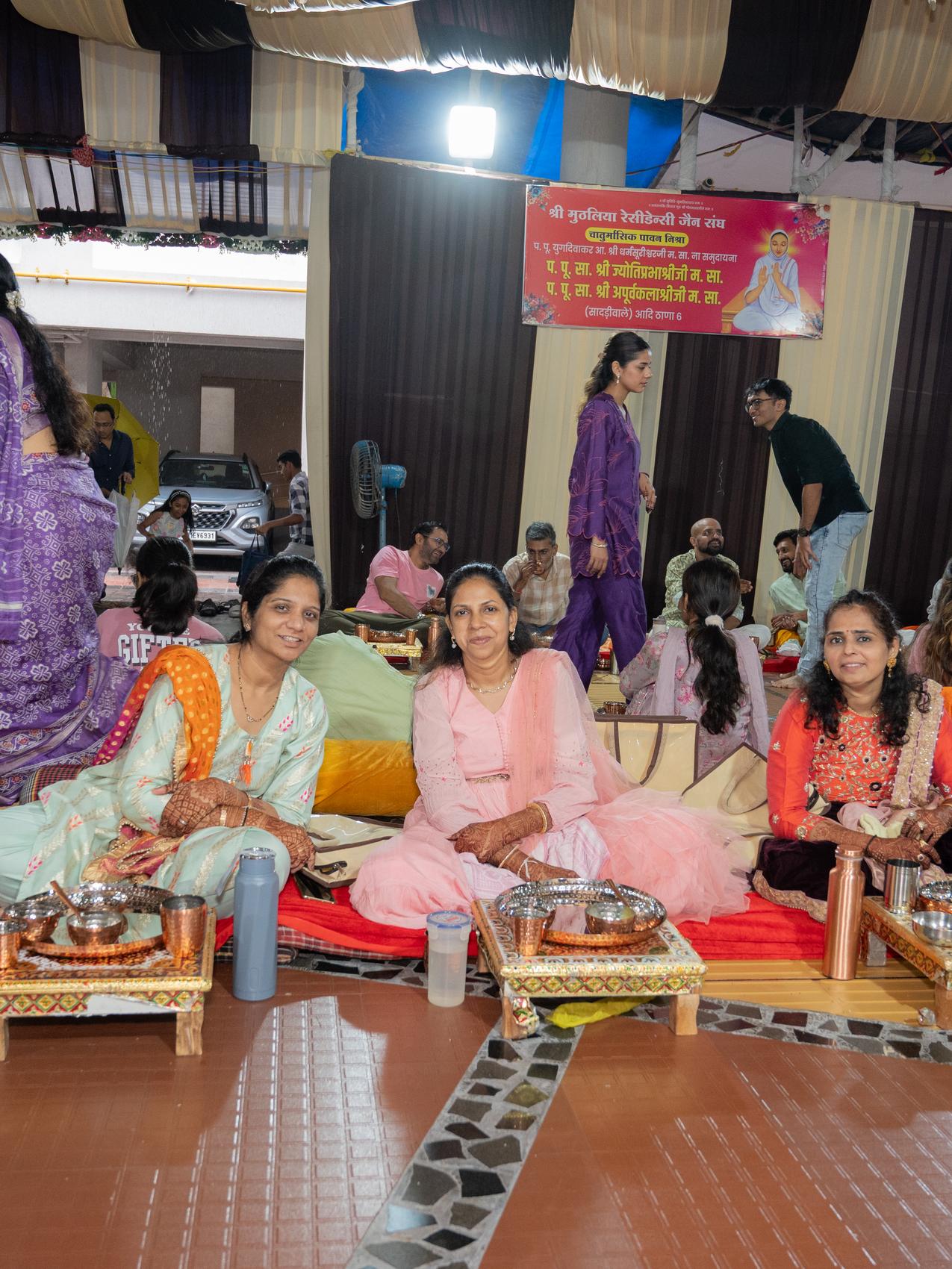 Families seated with puja thalis during a sanskar ceremony