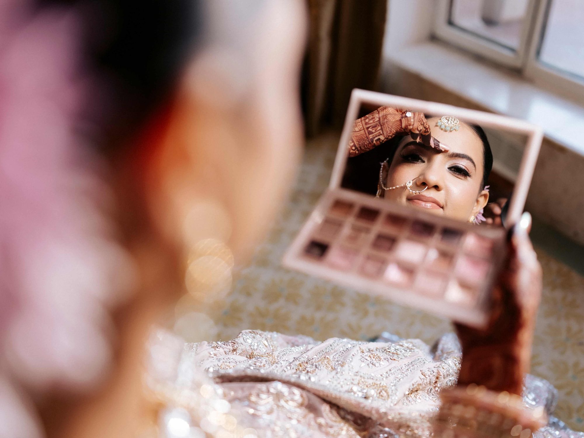Bride checking her reflection in a compact mirror